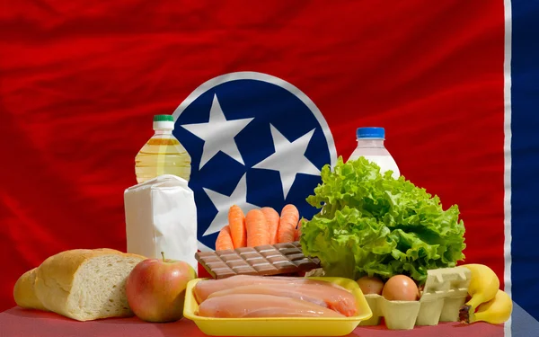Abarrotes de alimentos básicos frente a la bandera del estado tennessee nosotros — Foto de Stock
