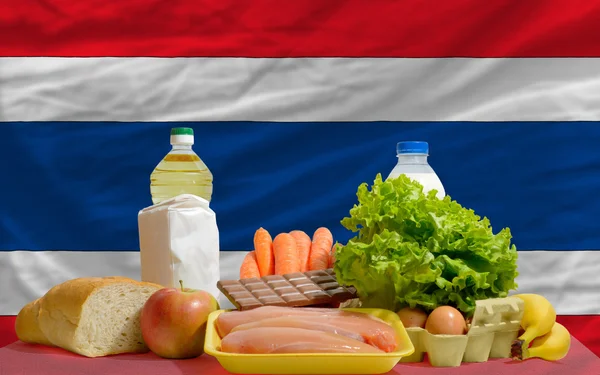 Основные продовольственные товары перед национальным флагом Таиланда — стоковое фото