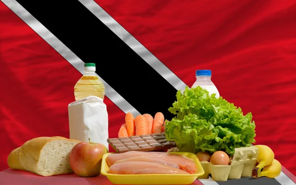 Основные продукты питания перед национальным флагом Тринидада Табаго — стоковое фото