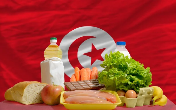 Abarrotes básicos de alimentos frente a la bandera nacional de Tunisia —  Fotos de Stock