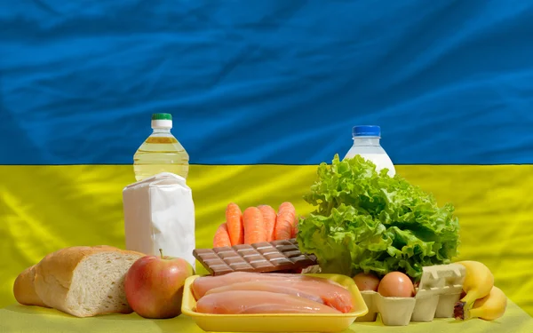 Grundläggande mat matvaror framför Ukraina nationella flagga — Stockfoto