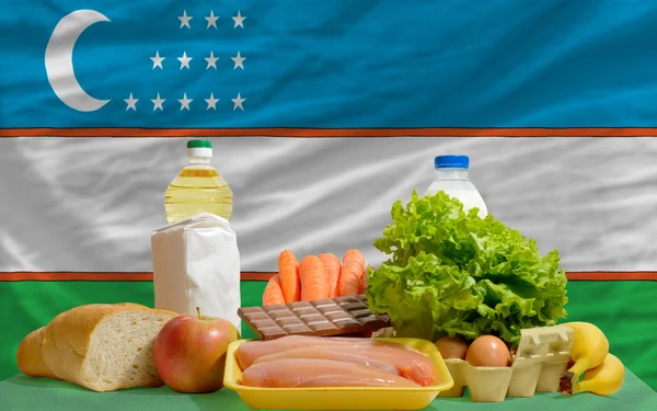 Mercearia alimentar básica em frente à bandeira nacional do Uzbequistão — Fotografia de Stock