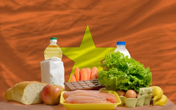 Abarrotes de alimentos básicos frente a la bandera nacional de Vietnam — Foto de Stock