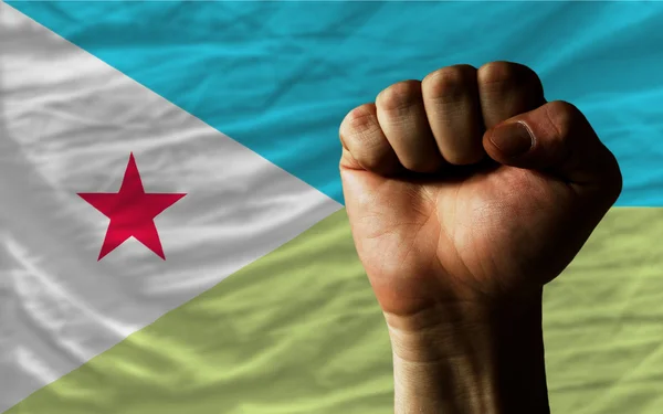 Hard fist in front of djibouti flag symbolizing power — Stock Photo, Image