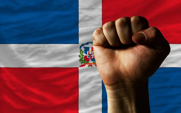 Kemény ököl szimbolizáló ereje Dominikai zászló előtt — Stock Fotó