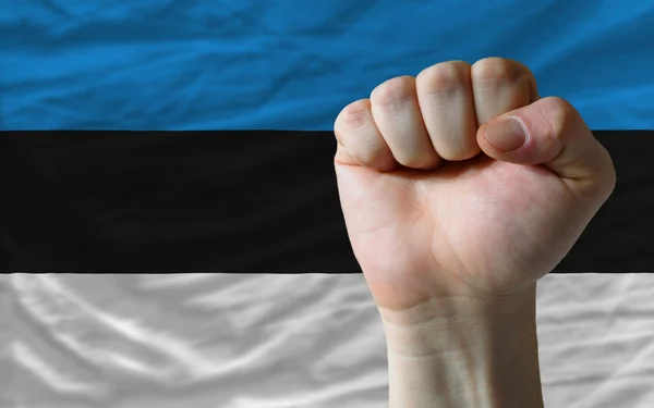 Sert yumruk gücü simgeleyen Estonya bayrağı önünde — Stok fotoğraf