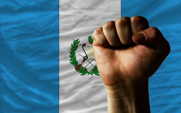 Punho duro na frente da bandeira guatemala simbolizando poder — Fotografia de Stock