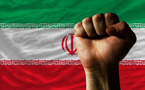 Жесткий кулак перед иранским флагом символизирует власть — стоковое фото