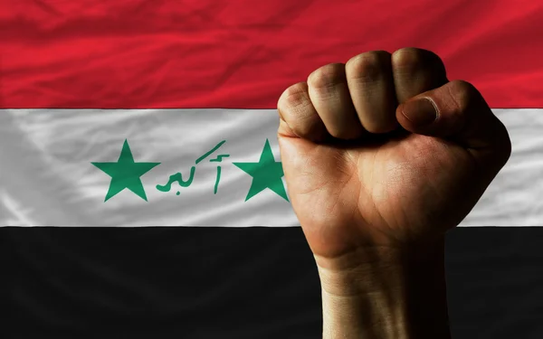 Hard fist in front of iraq flag symbolizing power — Stock Photo, Image