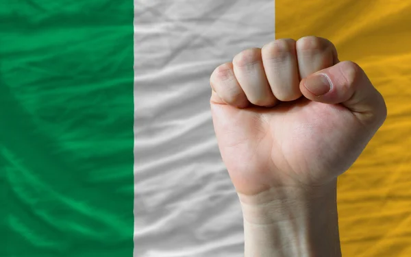 Punho duro na frente da bandeira irlandesa simbolizando poder — Fotografia de Stock