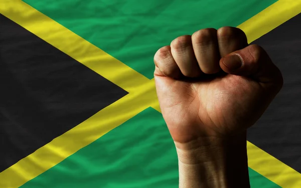 Pugno duro davanti alla bandiera giamaica che simboleggia il potere — Foto Stock