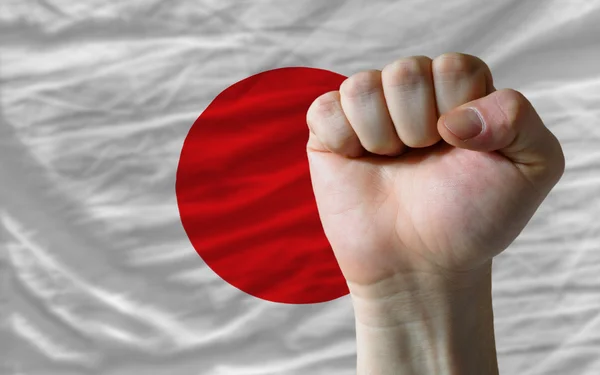 Puño duro frente a la bandera de Japón que simboliza el poder —  Fotos de Stock