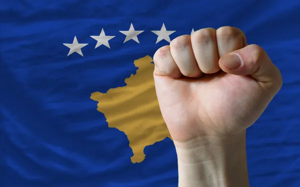 Punho duro na frente da bandeira kosovo simbolizando poder — Fotografia de Stock