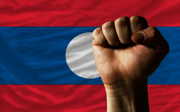 Puño duro frente a la bandera de Laos simbolizando el poder — Foto de Stock