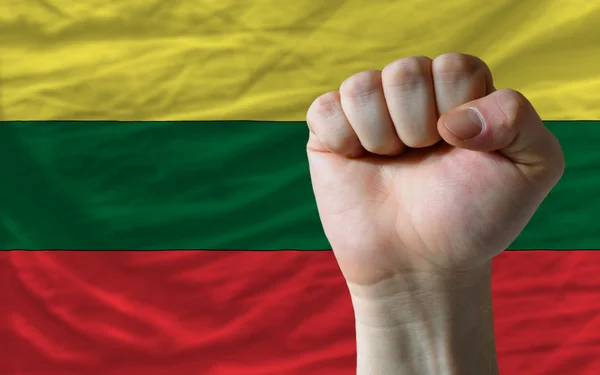 Жесткий кулак перед флагом Литвы, символизирующим власть — стоковое фото
