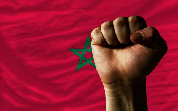 Puño duro frente a la bandera de Marruecos que simboliza el poder — Foto de Stock