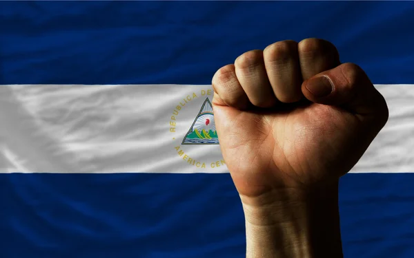 Tvrdá pěst před Nikaragua vlajku symbolizující sílu — Stock fotografie