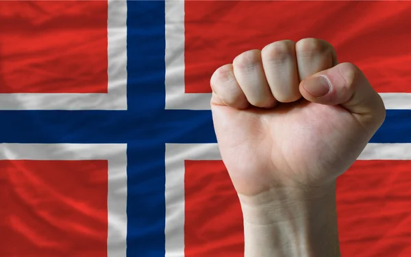 Жесткий кулак перед флагом Норвегии символизирует власть — стоковое фото