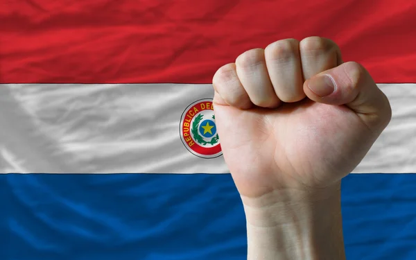 Punho duro na frente da bandeira do paraguai simbolizando o poder — Fotografia de Stock