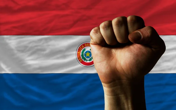 Pugno duro davanti alla bandiera paraguay che simboleggia il potere — Foto Stock