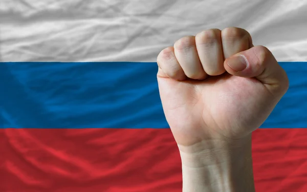 Жесткий кулак перед российским флагом символизирует власть — стоковое фото