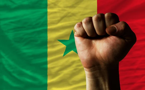 Pugno duro davanti alla bandiera senegalese che simboleggia il potere — Foto Stock