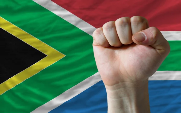 Pugno duro davanti alla bandiera sudafricana che simboleggia il potere — Foto Stock