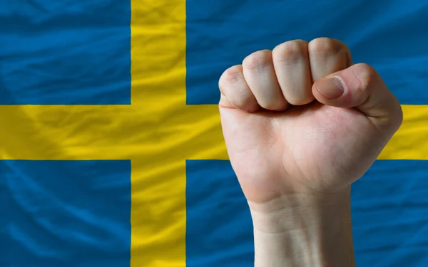 Punho duro na frente da bandeira sueca simbolizando o poder — Fotografia de Stock