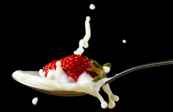 stock image Red, ripe strawberry falling in spoon with milk