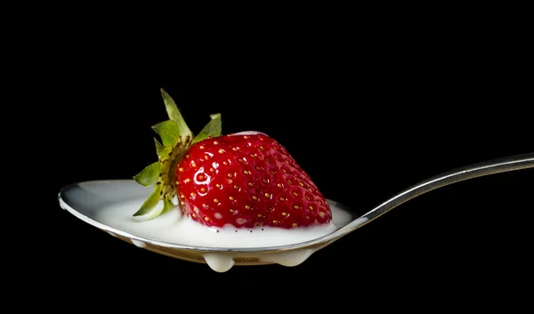 stock image Red, ripe strawberry falling in spoon with milk