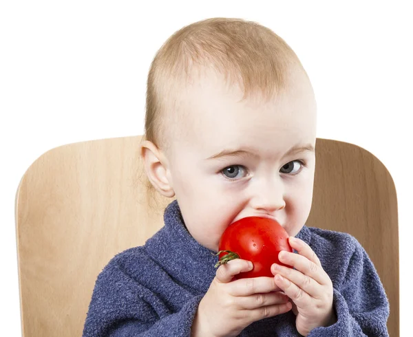 Niño pequeño comiendo tomates en silla alta — Foto de Stock