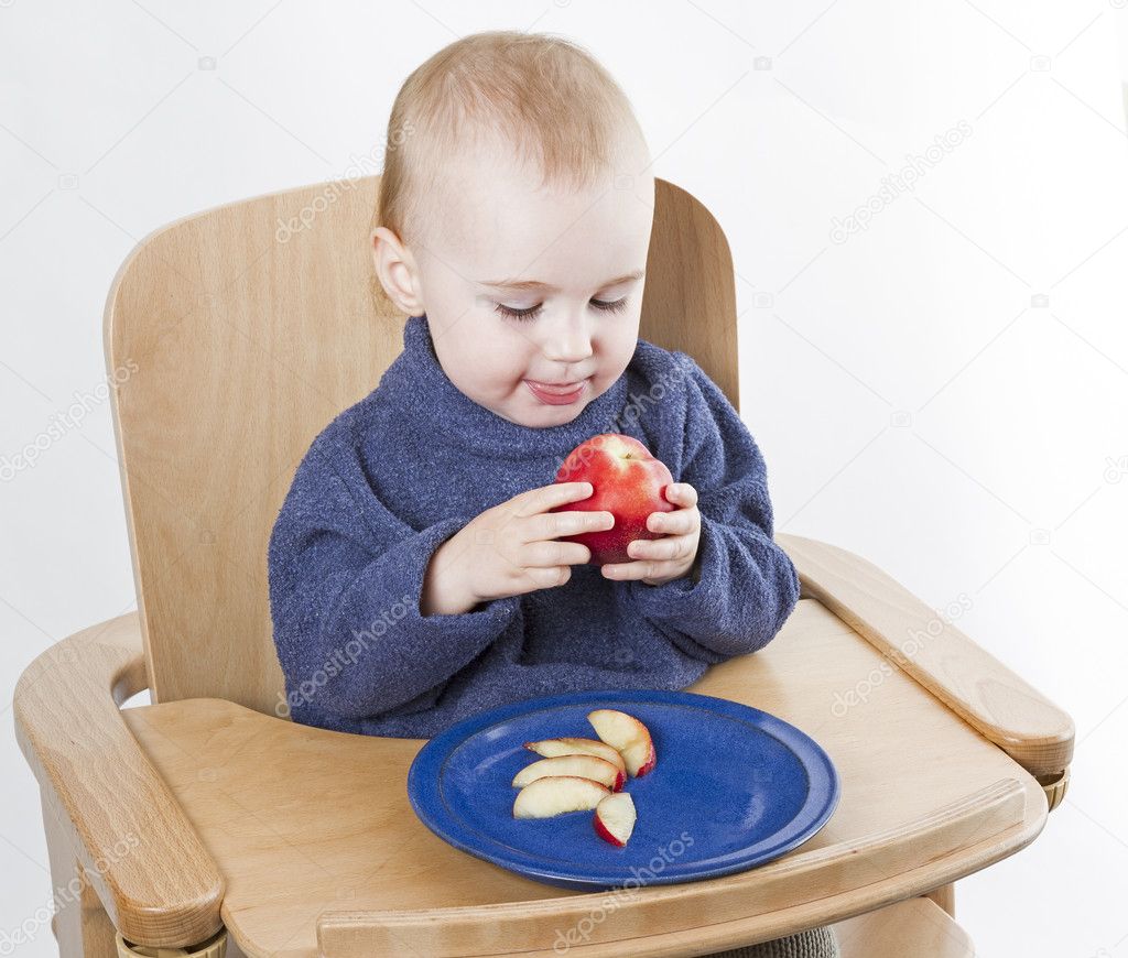 Young child eating peaches in high chair