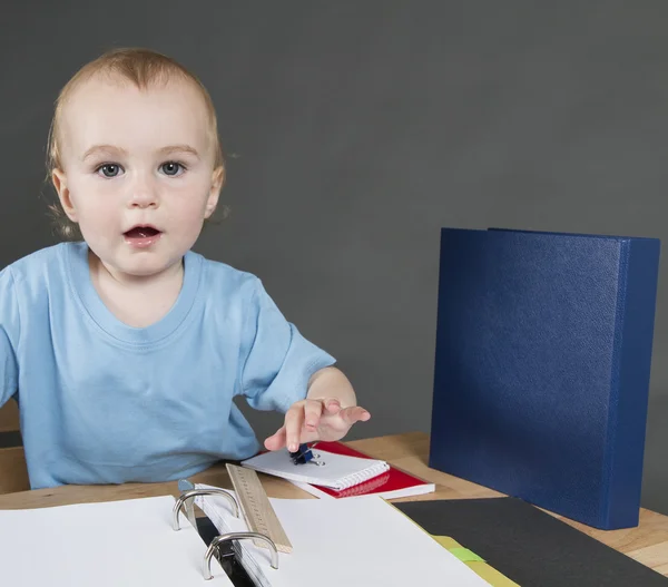 Kind met papierwerk bij klein bureau — Stockfoto
