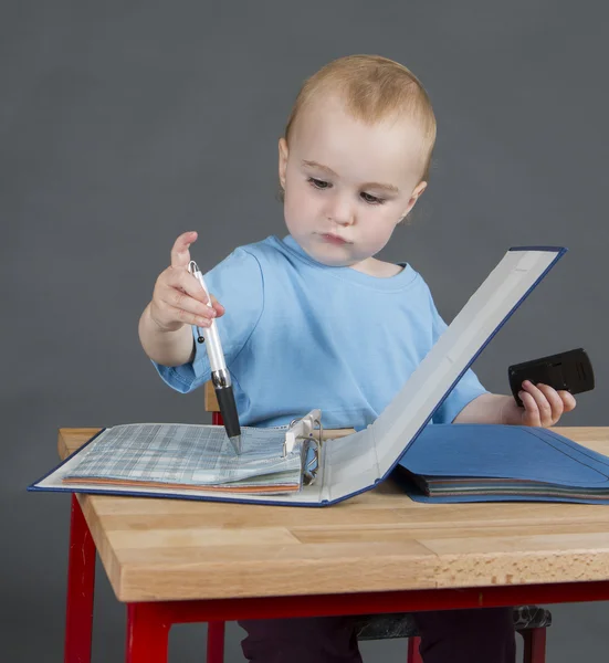 Baby with paperwork at wooden desk — Stock Photo, Image