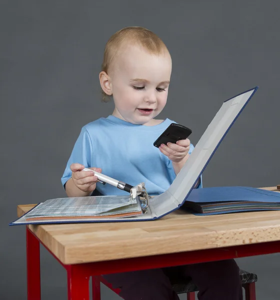 Baby with paperwork and calculator at wooden desk — Stock Photo, Image