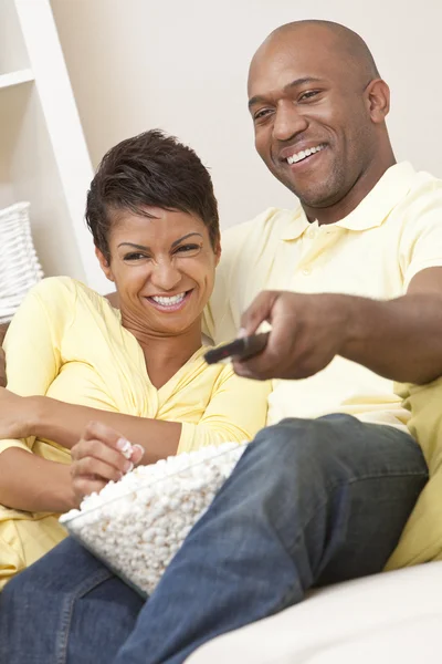 Pareja afroamericana comiendo palomitas viendo televisión — Foto de Stock