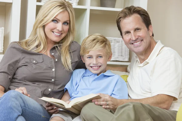 Счастливая семья, сидящая за книгой Софы — стоковое фото
