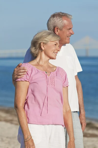 Счастливая пожилая пара обнимается на пляже — стоковое фото