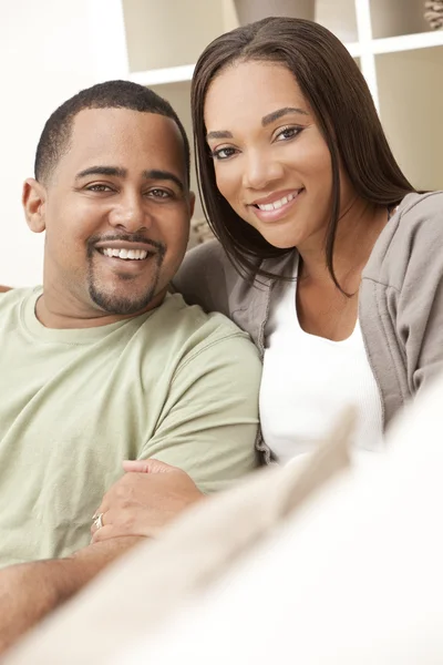 Счастливая афроамериканская пара сидит дома — стоковое фото