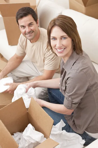 Glückliches Paar beim Auspacken oder Packen von Kartons beim Umzug — Stockfoto