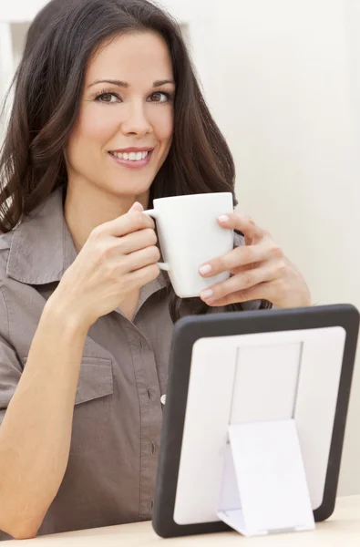 Mujer usando Tablet Computer en casa bebiendo té o café —  Fotos de Stock