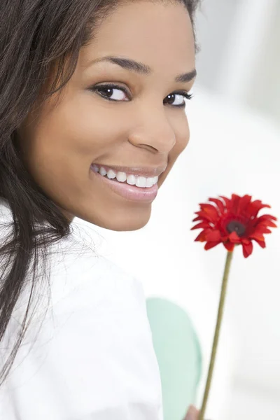 Afrikalı-Amerikalı kadın ile kırmızı çiçek gülümseyen — Stok fotoğraf