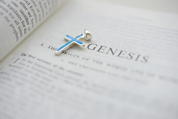 Cruxific close to the word Genesis on the bible — Stock Photo, Image