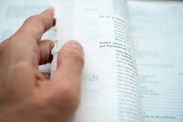 Hand flipping the bible pages with shallow DOF — Stock Photo, Image
