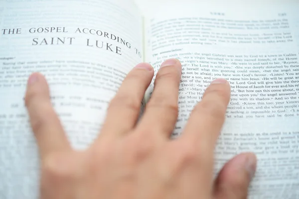 Рука переворачивает библейское Евангелие с мелким DOF — стоковое фото