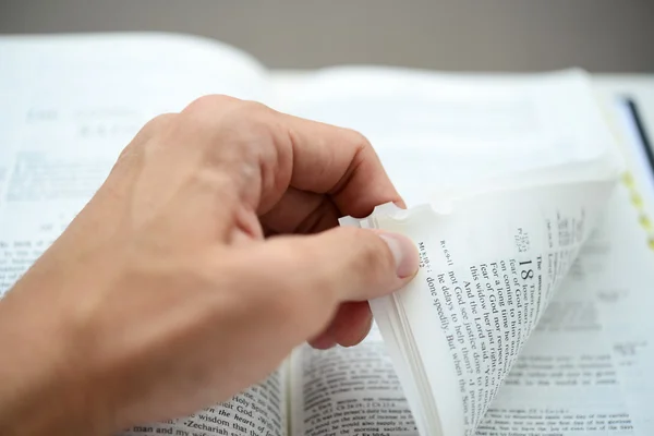 Hand flipping corner of the bible with shallow DOF — Stock Photo, Image