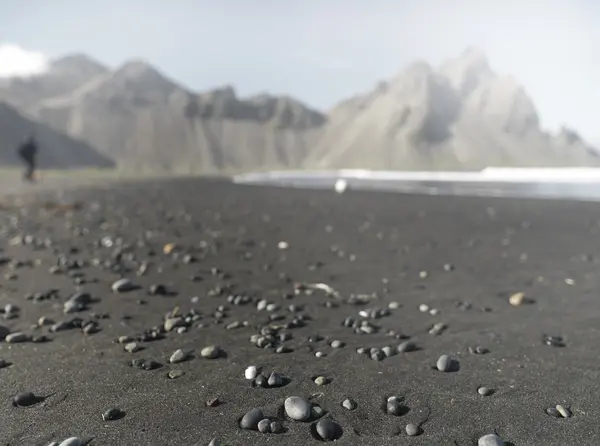 Pebbles ao longo da praia com viajante em segundo plano — Fotografia de Stock