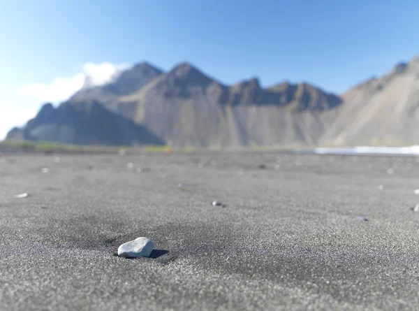 Small rock with mountains in the background