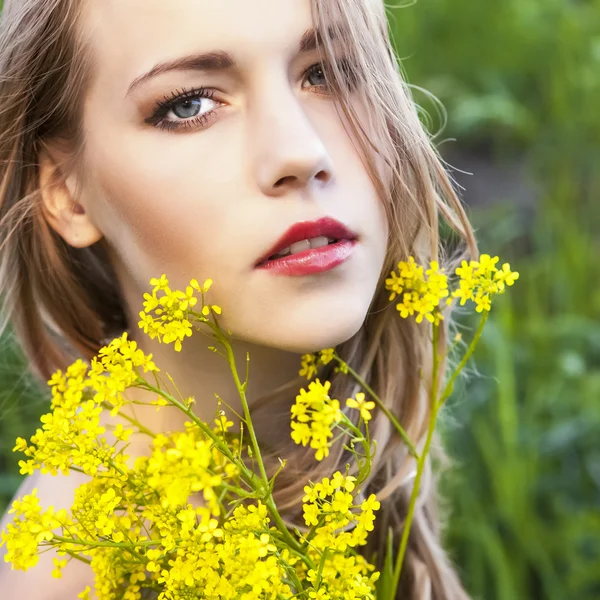 Porträt der jungen schönen Frau mit Blumen — Stockfoto