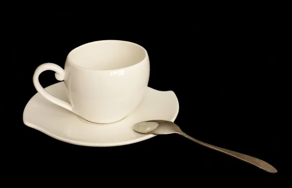 Гарна чашка кави і тарілка і ложка на чорному тлі — стокове фото